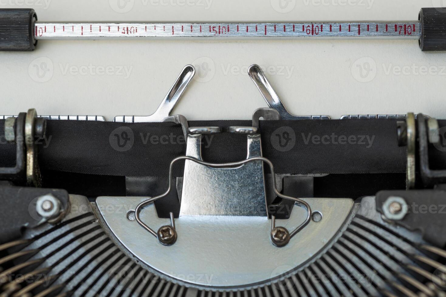 Old typewriter showing keys, ribbon and blank paper photo