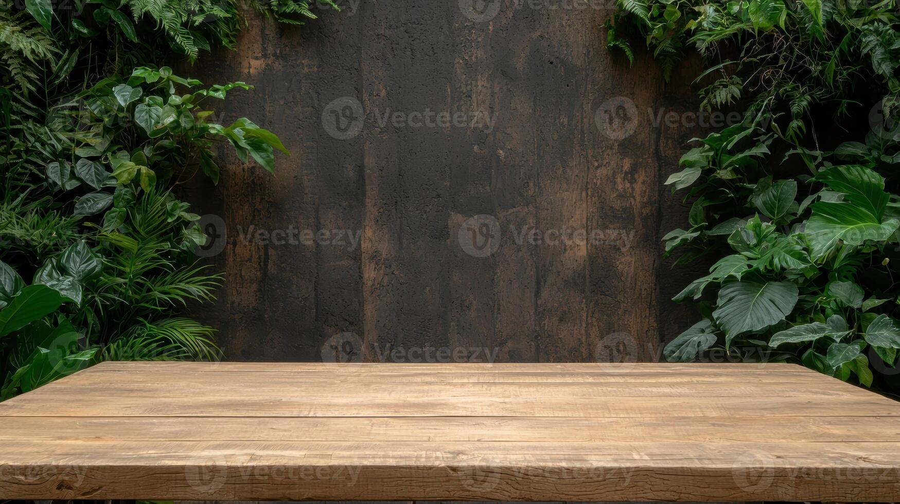 Empty wooden table with lush green plants and dark brown background photo