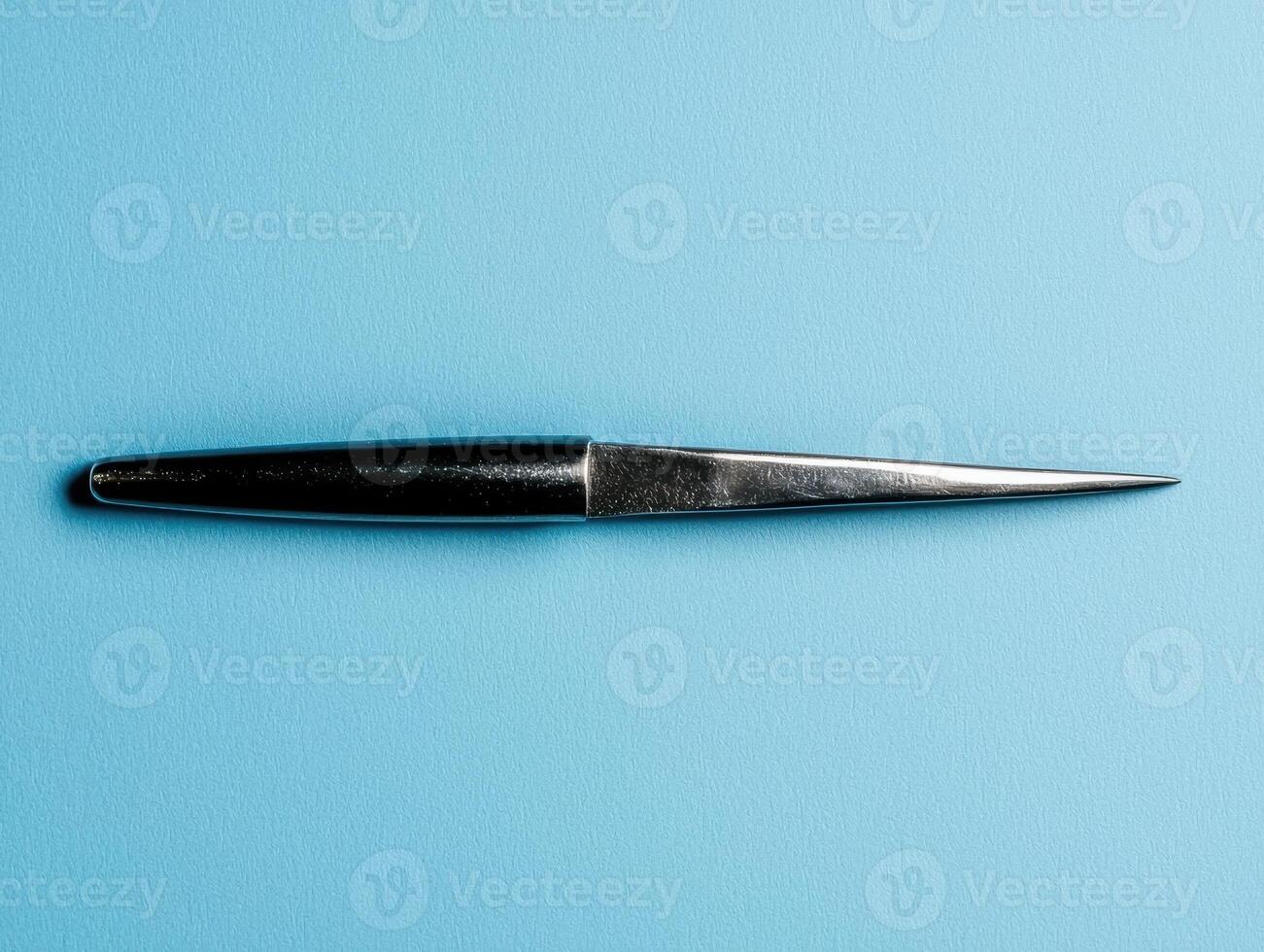 Sleek silver knife on a blue background photo