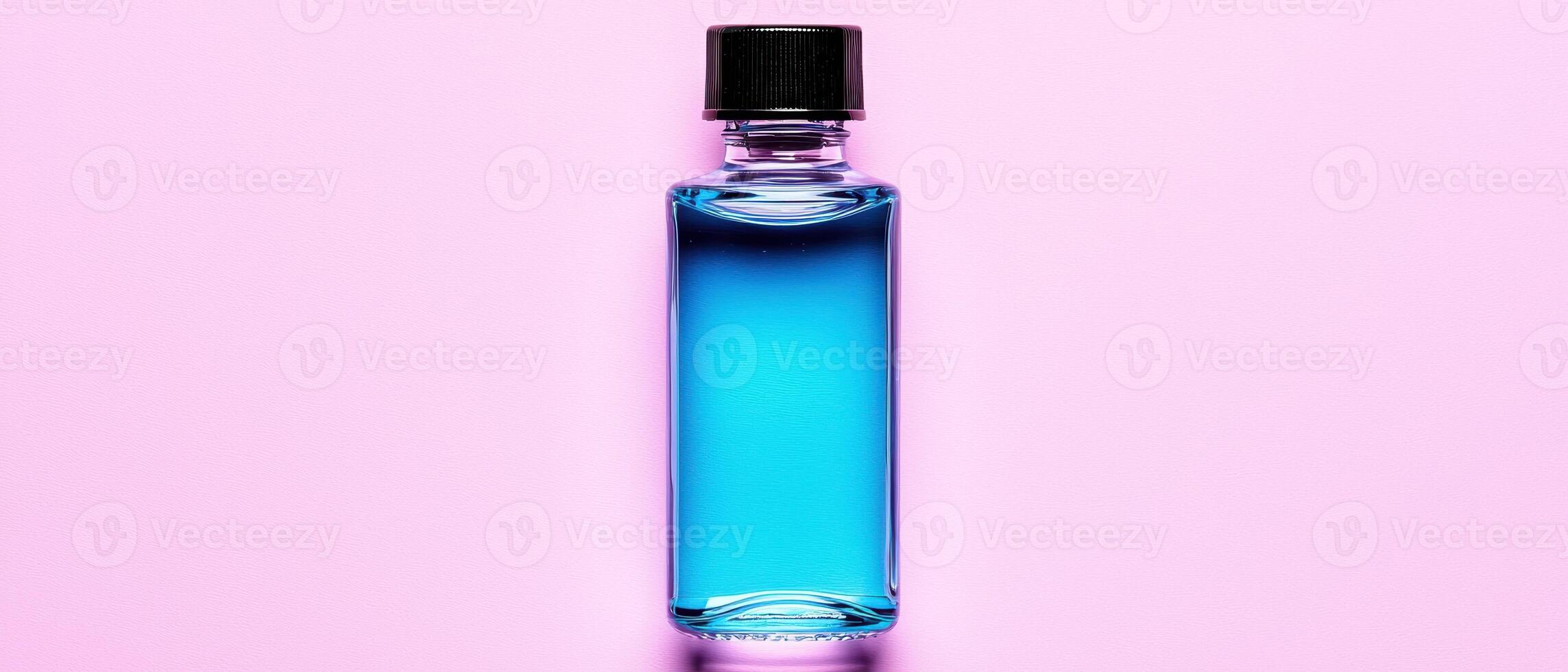 Blue liquid in a glass bottle on pink background photo