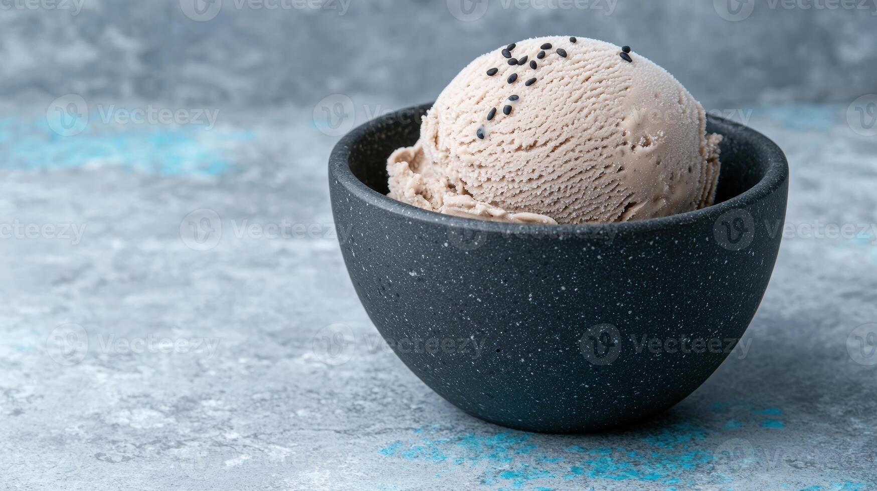 Close up of a scoop of delicious sesame ice cream in a dark bowl photo