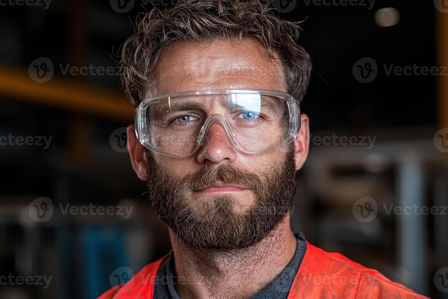 Portrait of a serious bearded worker wearing safety glasses photo