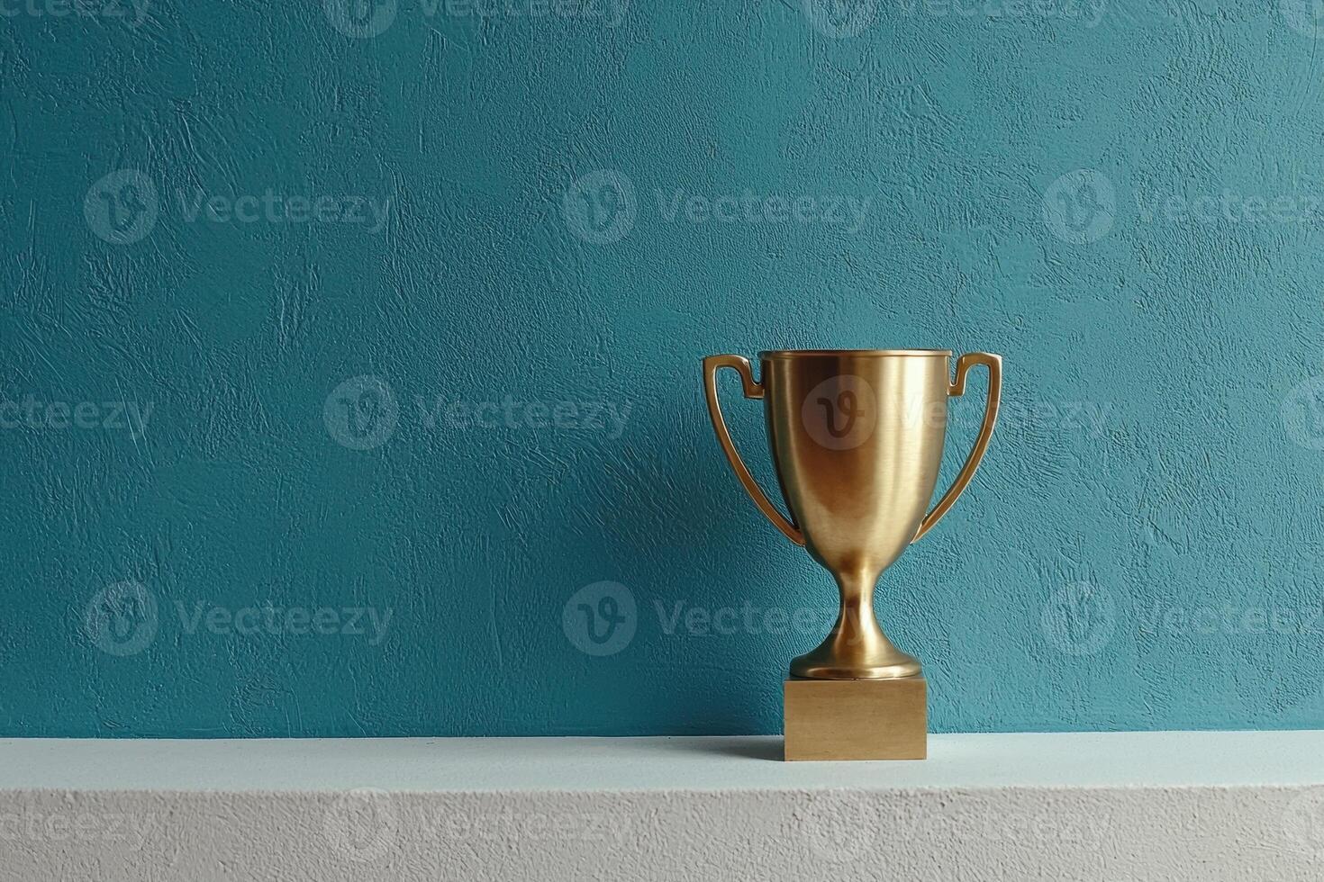 Gold trophy on white shelf against teal wall photo