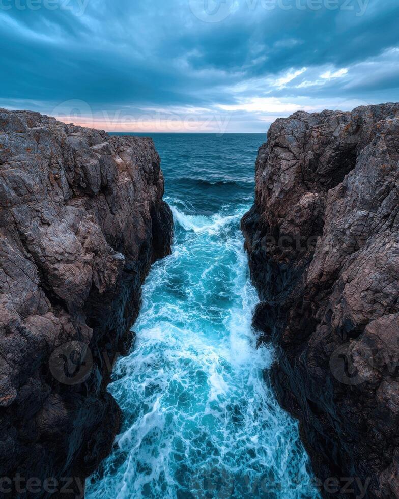 Waves crashing through a narrow passage between rocky cliffs photo