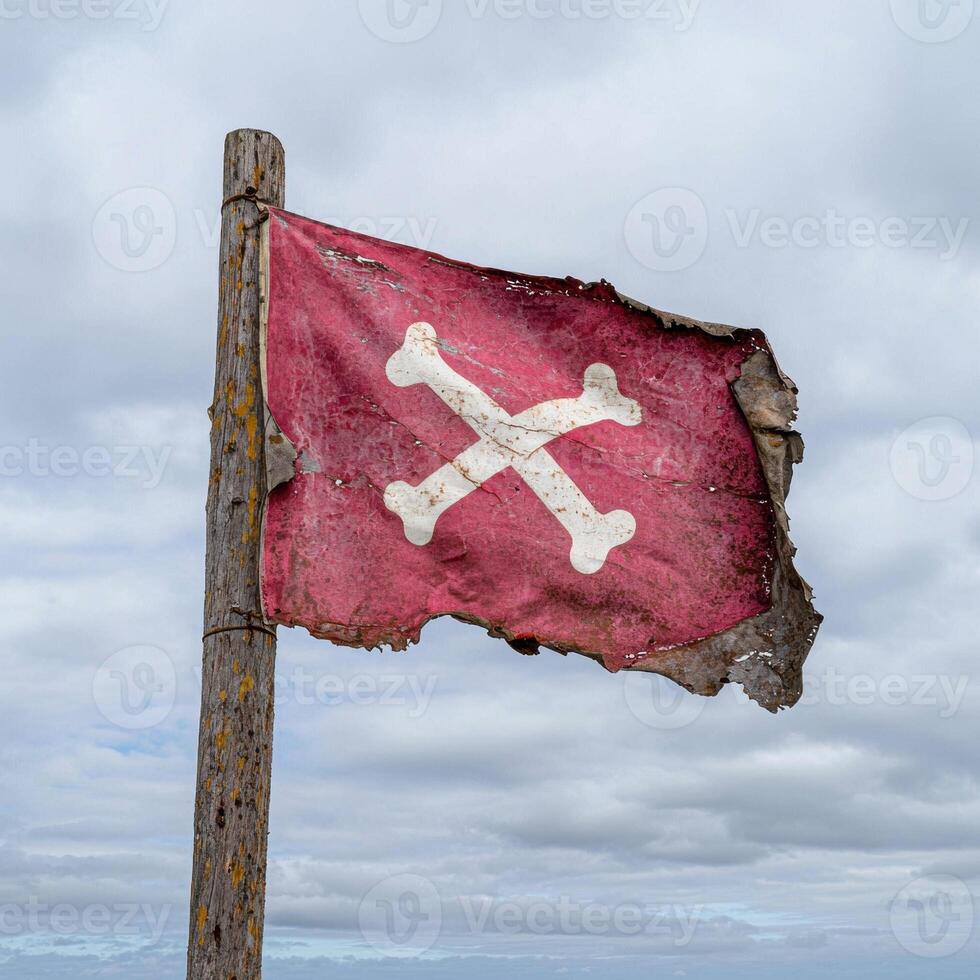 Torn pirate flag with skull and crossbones waving in the wind photo