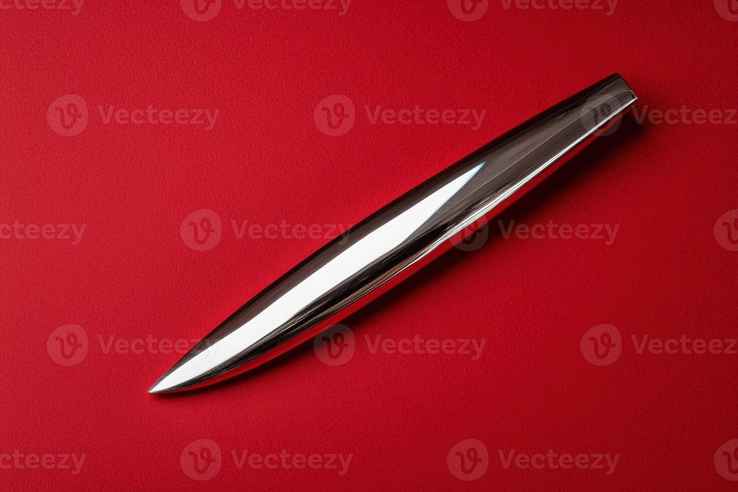 Sleek metallic object on red background photo