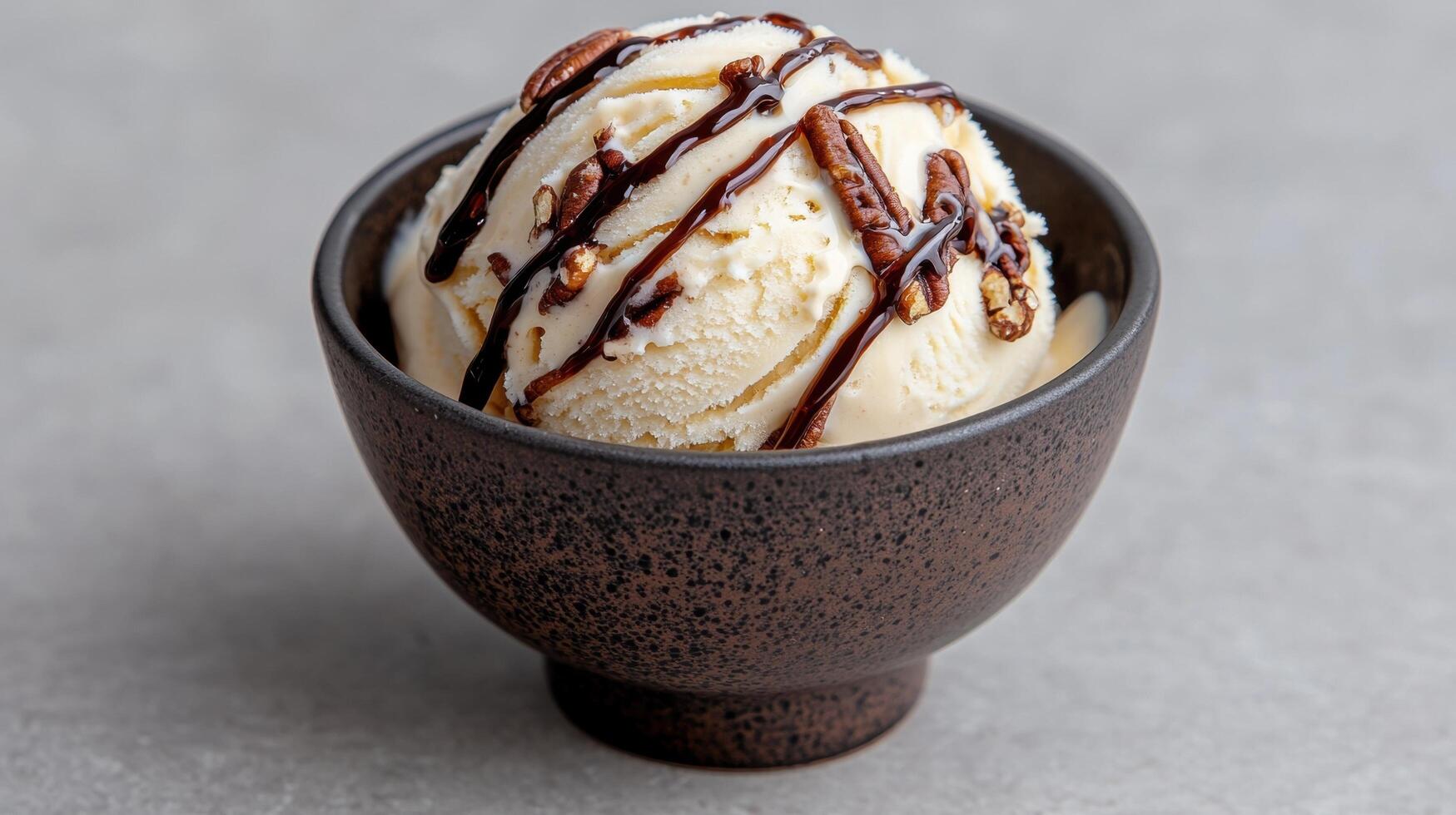 A scoop of creamy vanilla ice cream with pecans and chocolate sauce photo