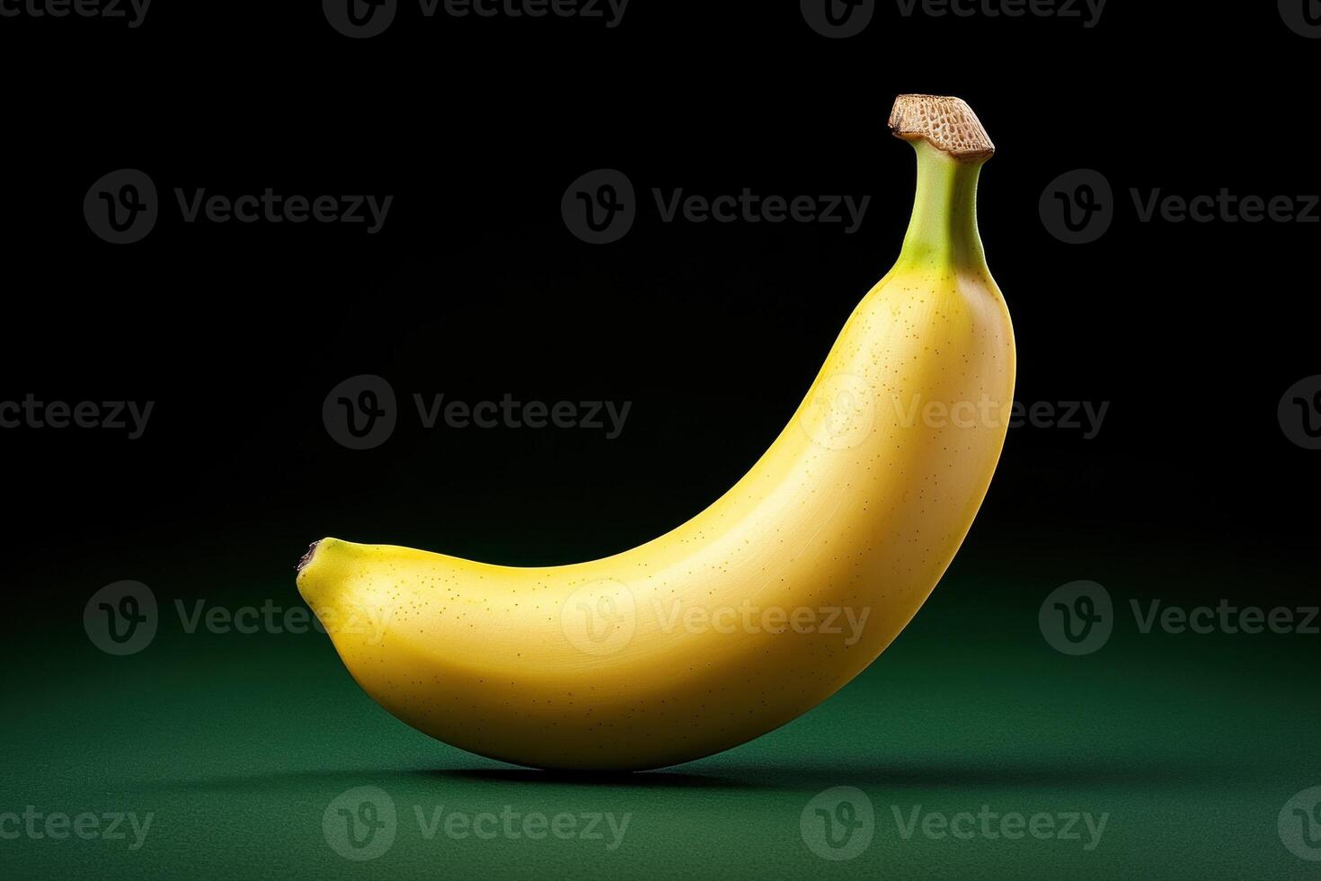 Single ripe yellow banana on a green background. photo