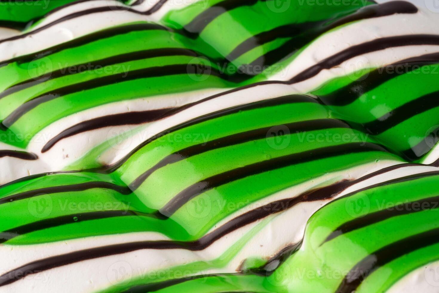 Green and white striped dessert with chocolate drizzle on a textured surface showcasing culinary art photo