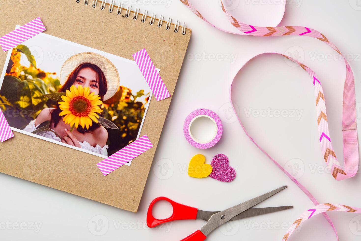 Crafting a scrapbook with a sunflower photo and colorful decoration materials on a light background