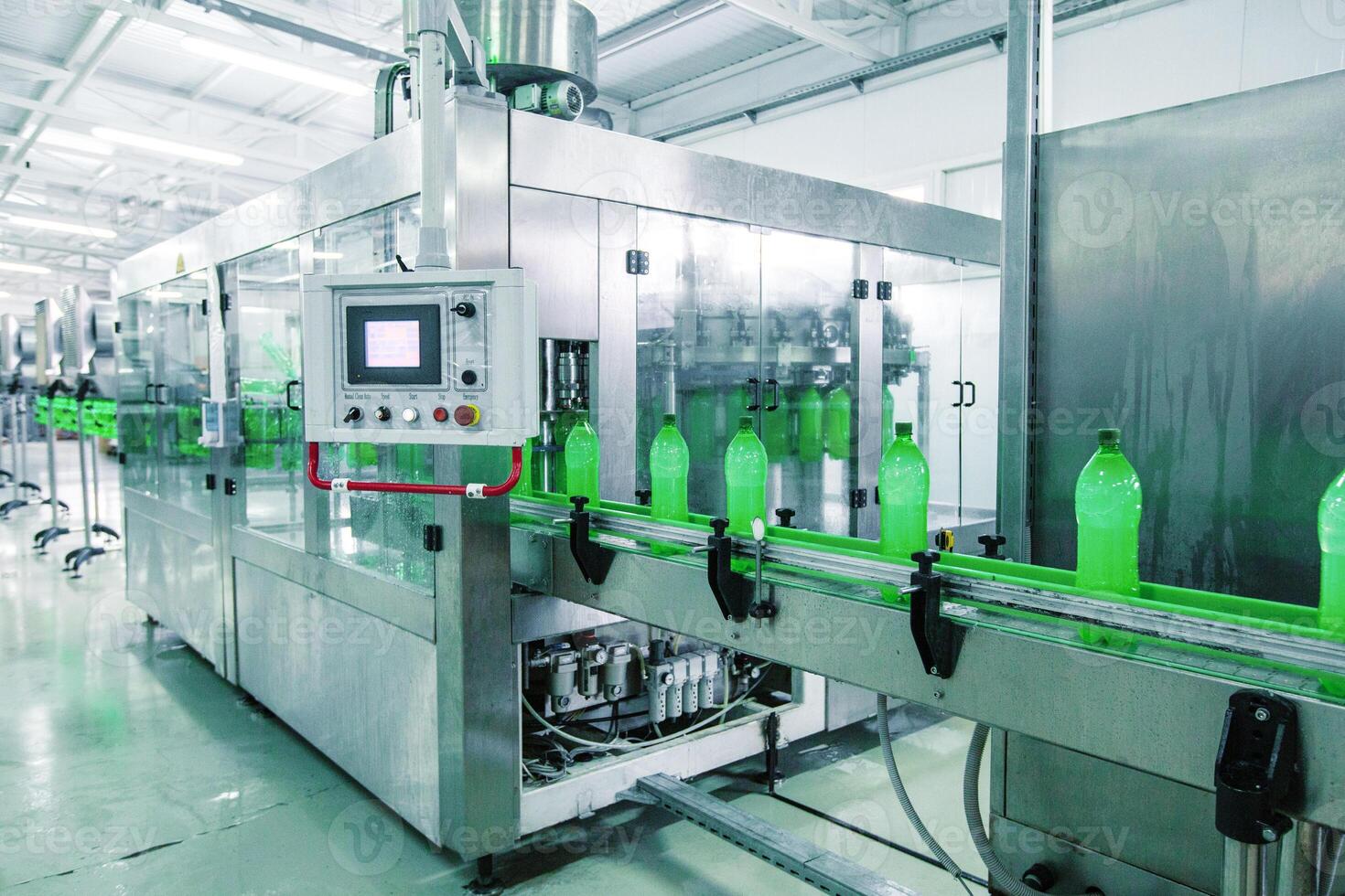 Bottle filling machine operates in a clean beverage production facility during daylight hours photo