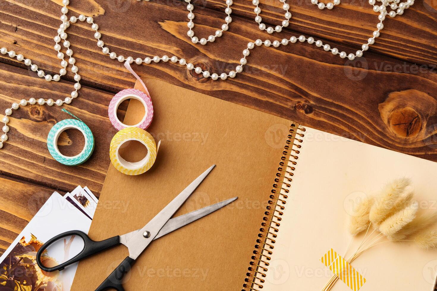 Crafting and creativity come alive with scissors, washi tape, and decorative supplies on a wooden table photo