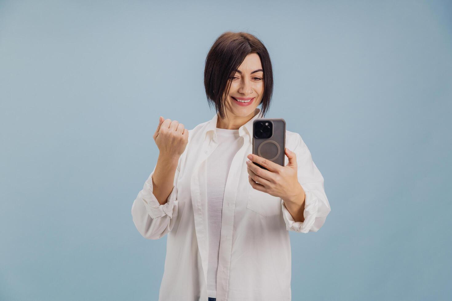 Enthusiastic mature businesswoman celebrating success on call photo