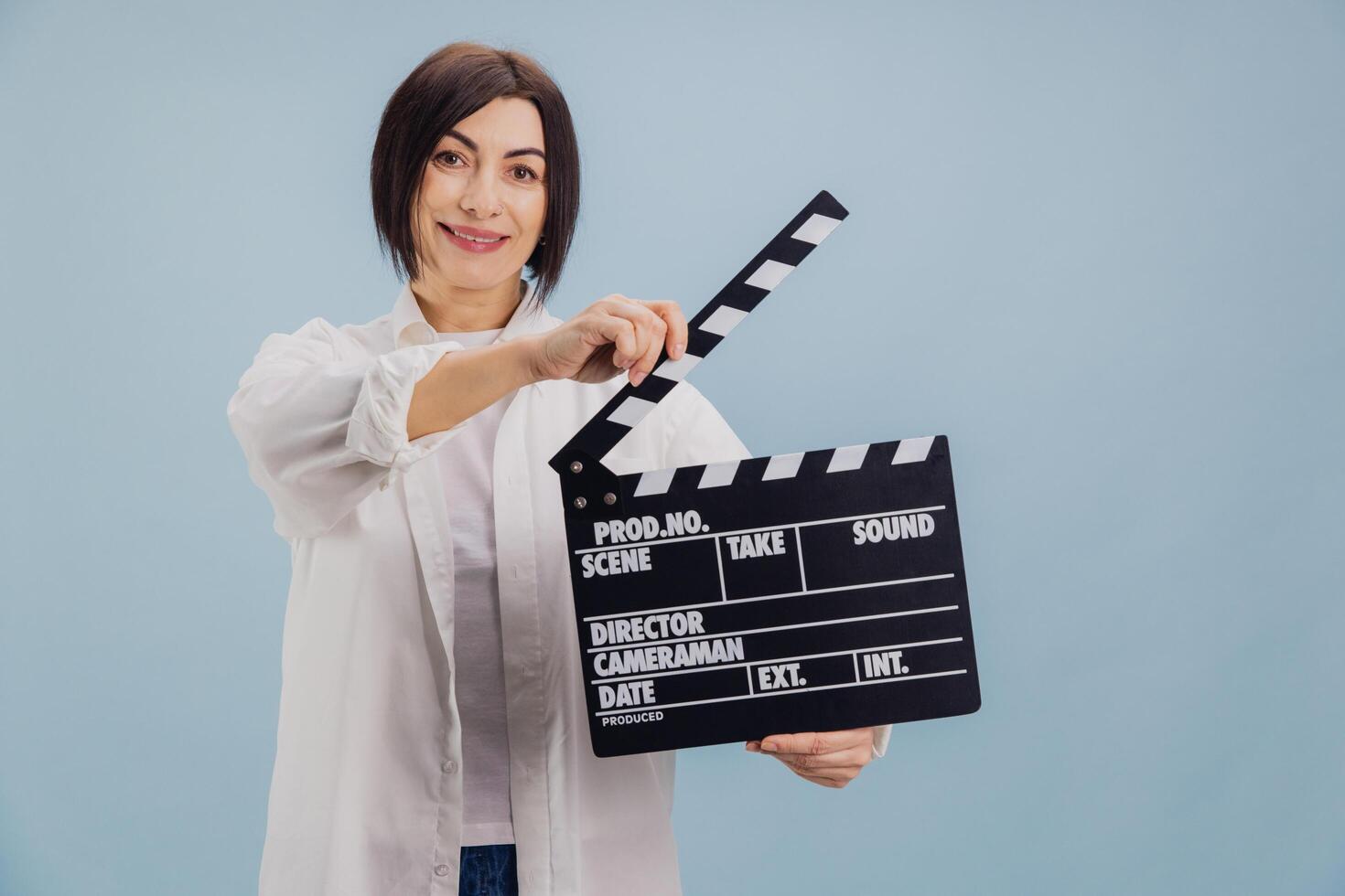 Film director using movie clapperboard on light blue background photo