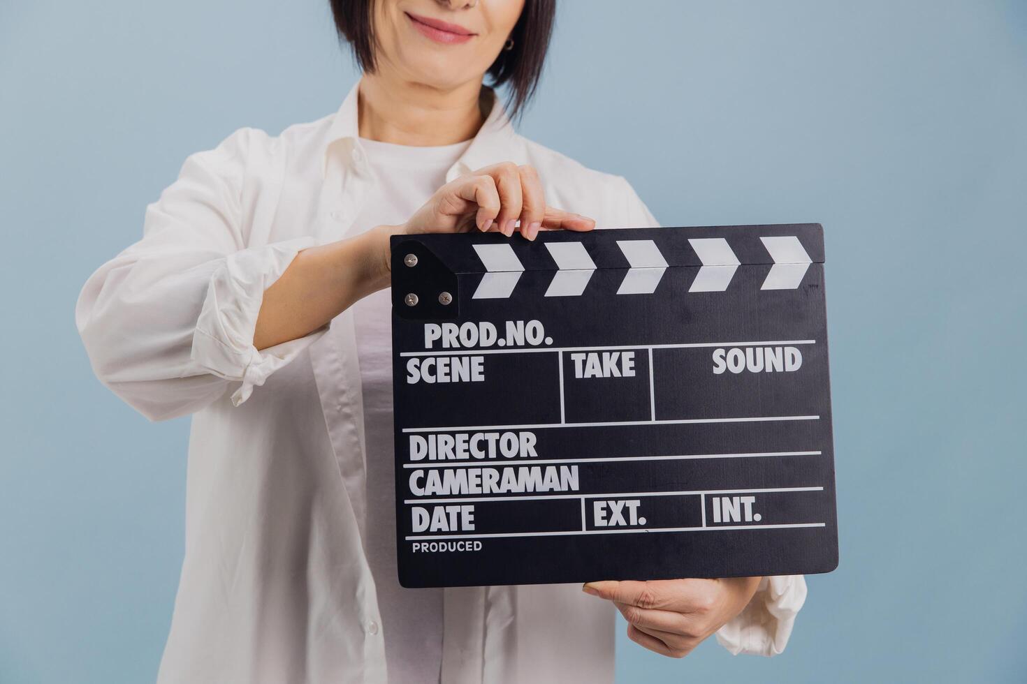 Film director holding movie clapperboard on blue background photo