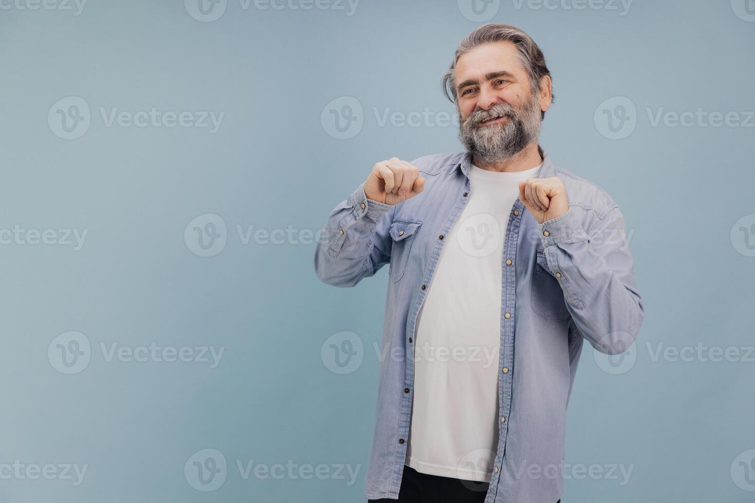Cheerful senior man dancing and having fun on blue background photo