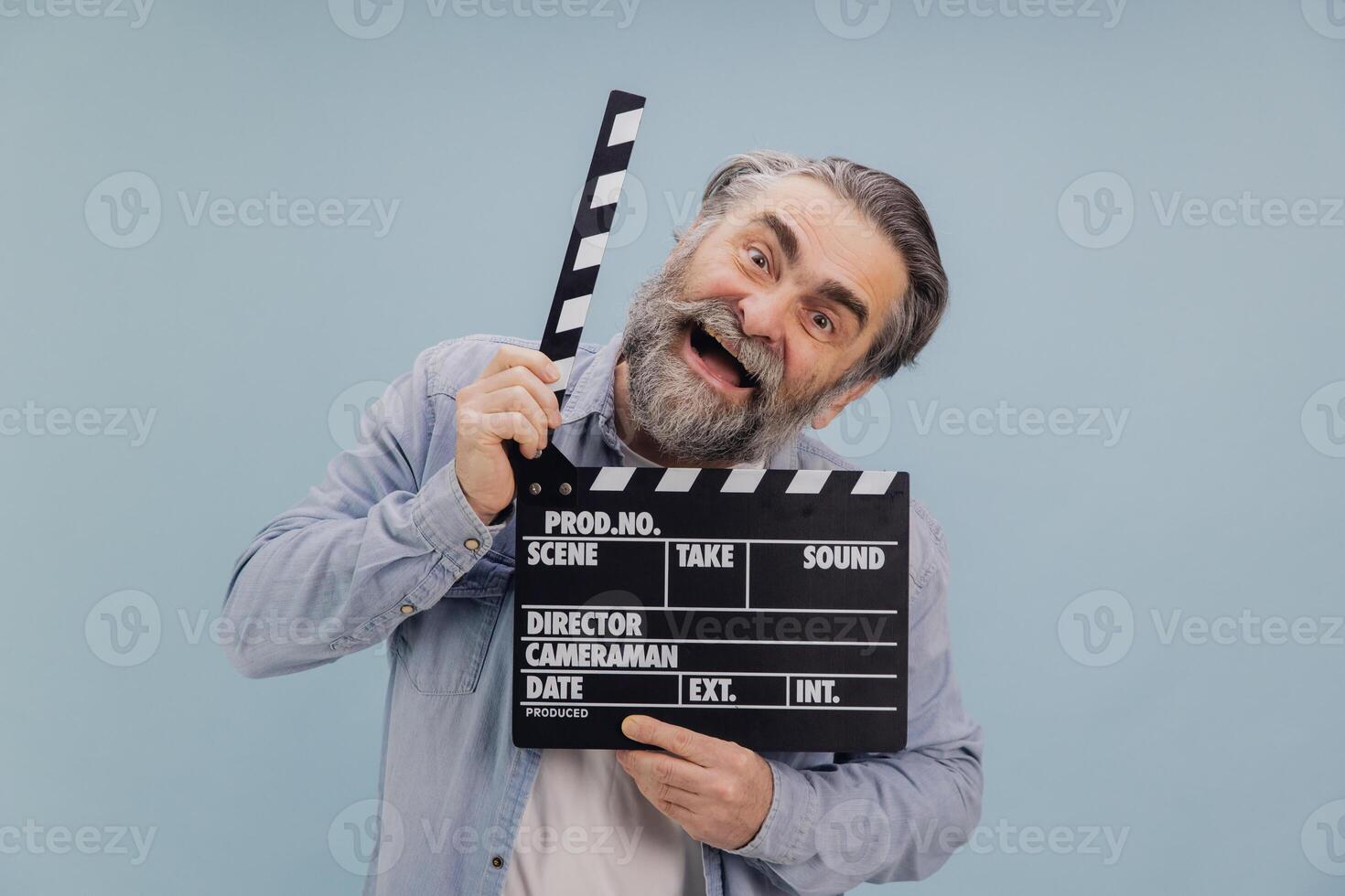 Excited senior film director holding movie clapperboard, smiling and having fun photo
