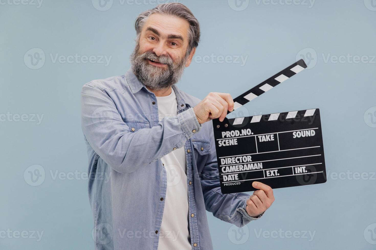 Smiling Senior Film Director Using Clapperboard on Set photo