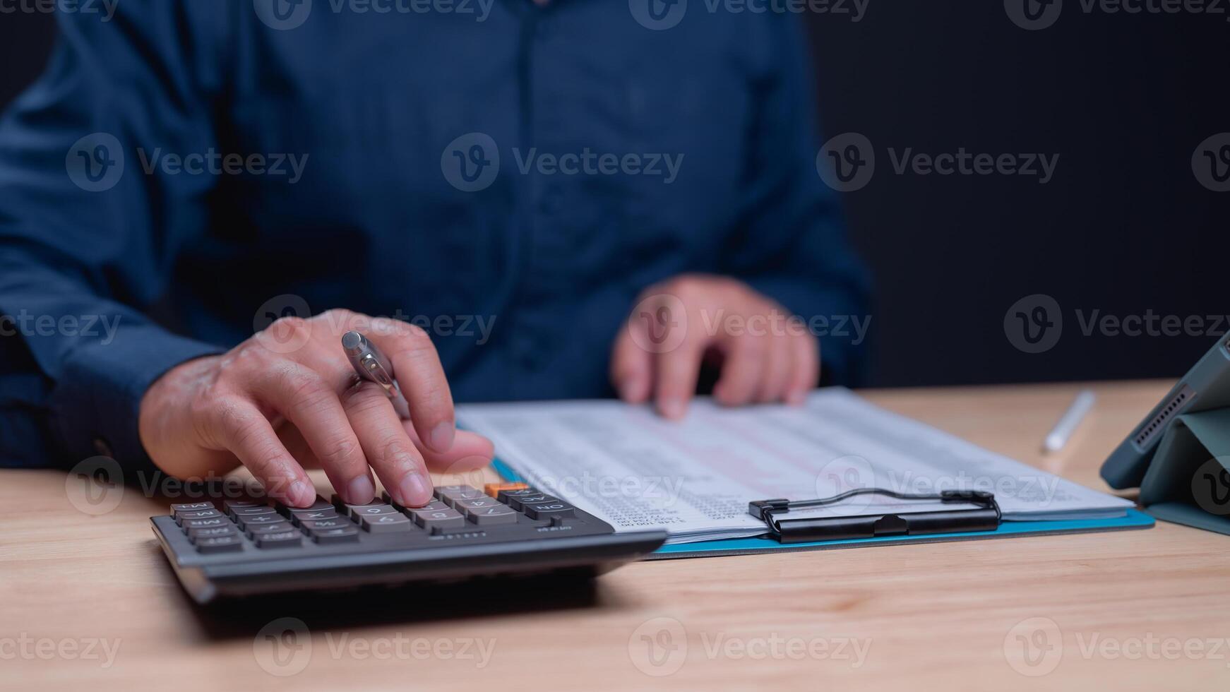 Crunching Numbers with Precision, Focused individual works on calculations using calculator, highlighting importance of accuracy in financial tasks photo