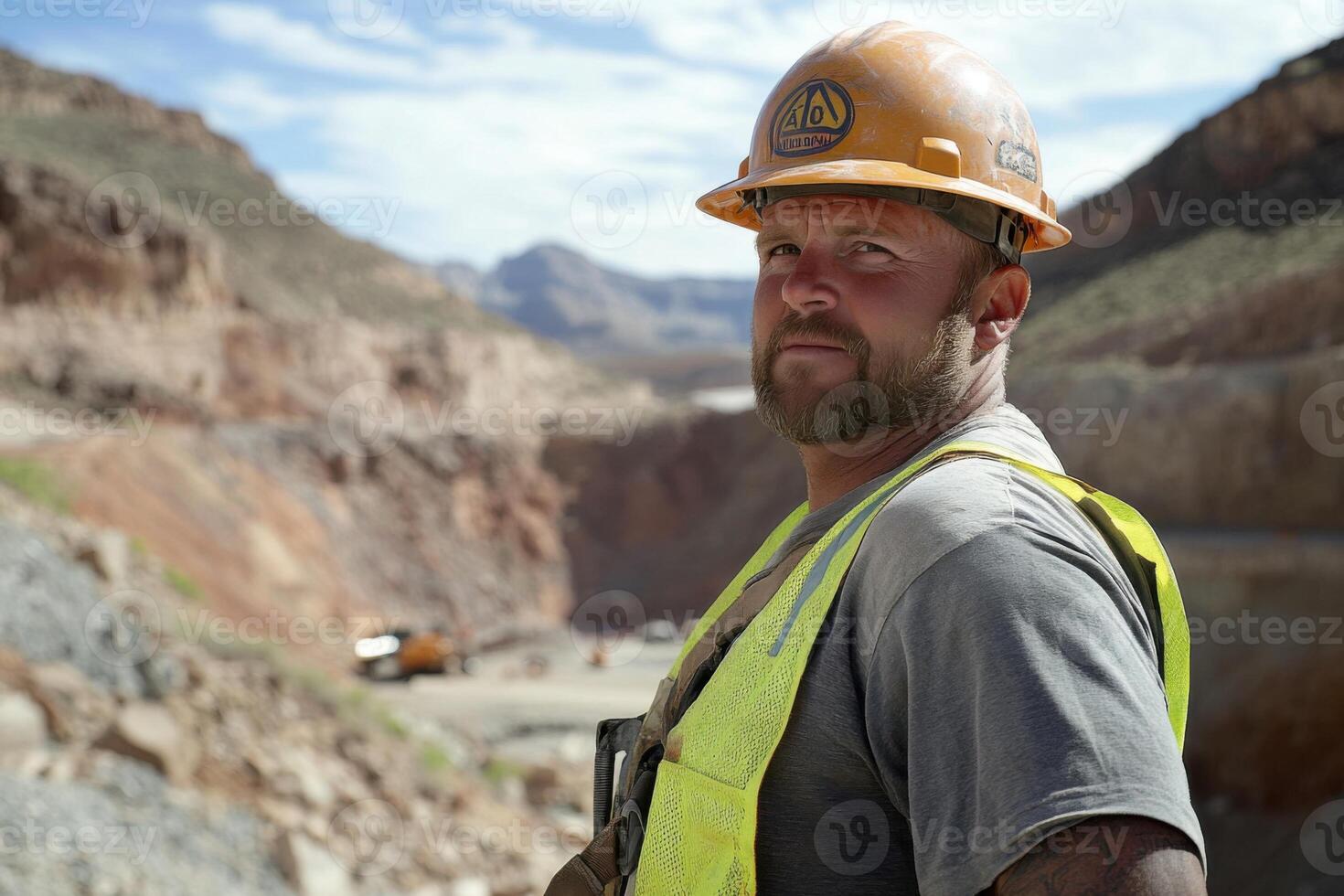 Construction worker reviewing progress at a mountain site during the day with equipment visible in the background photo