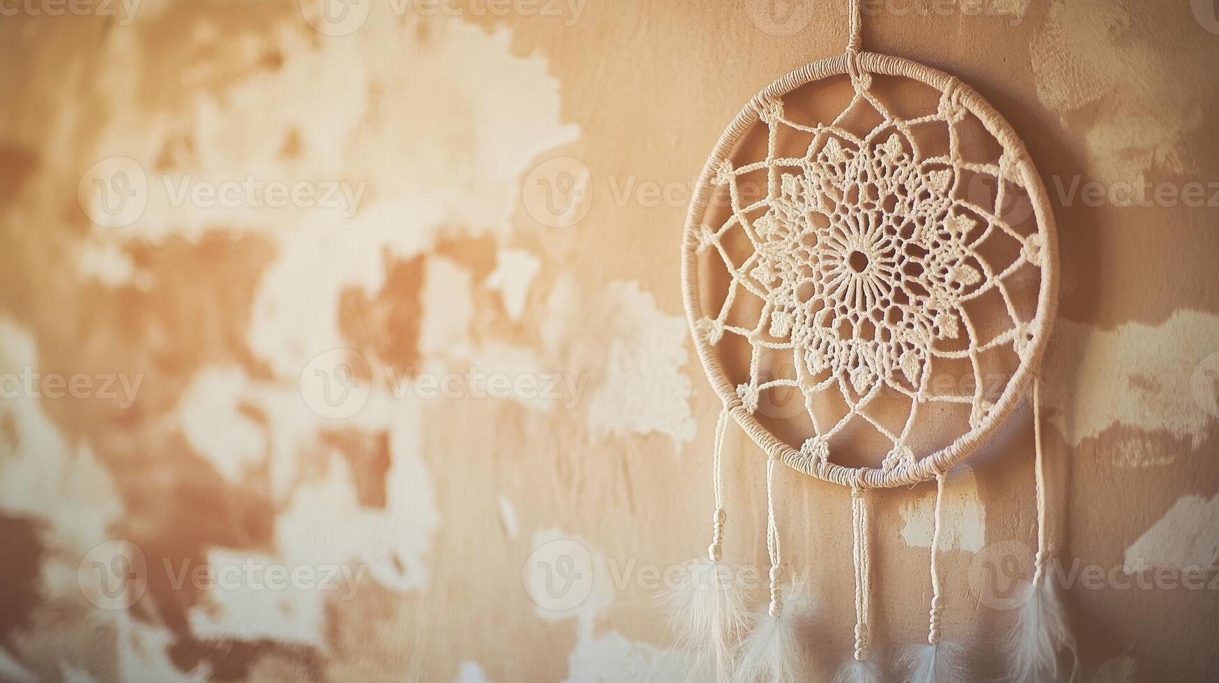 Decorative dream catcher hangs on a textured wall in a softly lit room, showcasing intricate lace design and natural materials photo