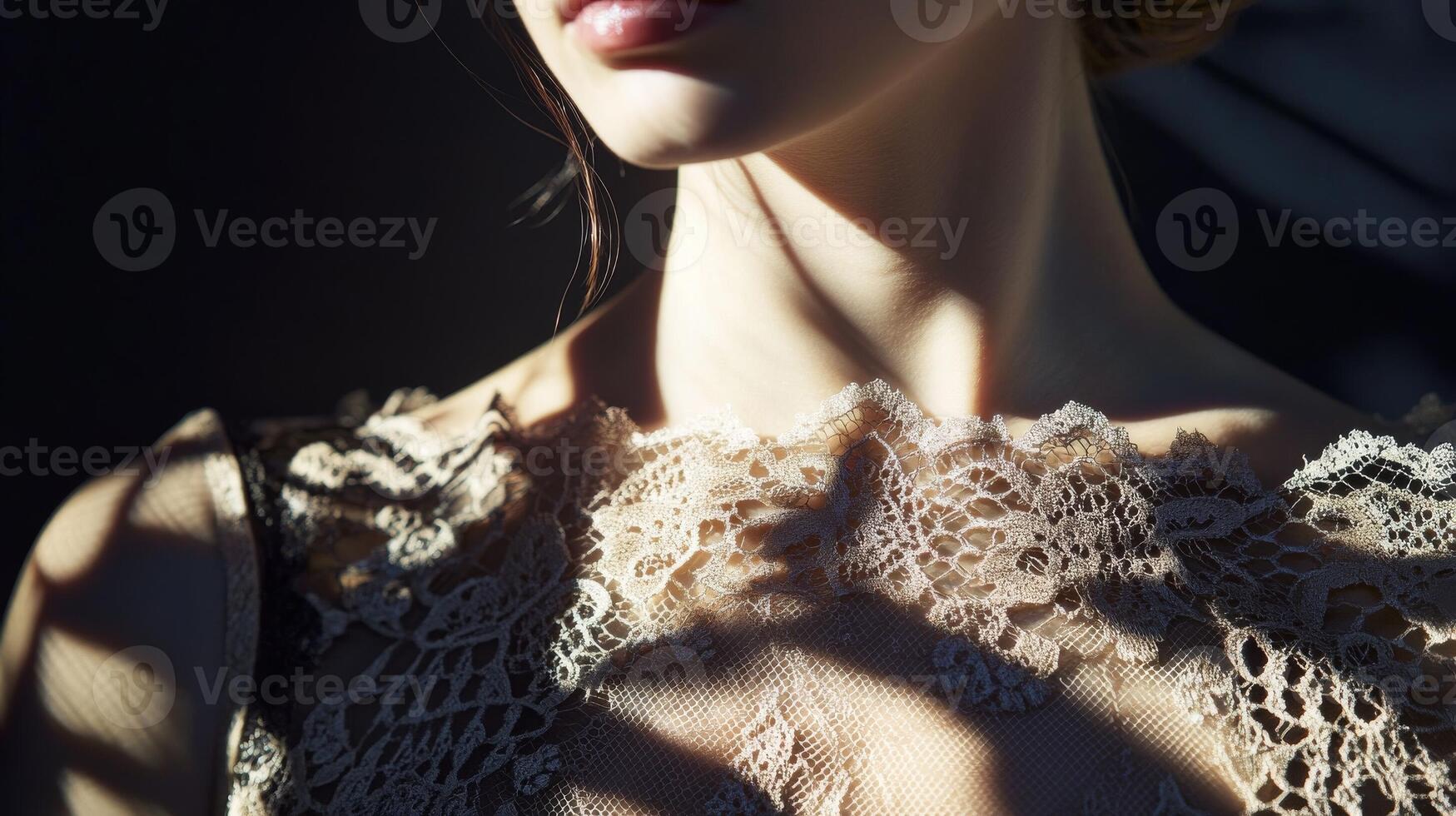 Light and shadow play on the neckline of a woman wearing delicate lace in a dimly lit space photo