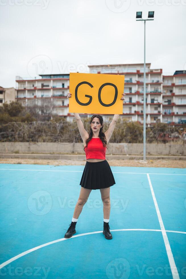 Cheerleader Girl Cheers Her Heart Team With Go Yellow Signboard photo
