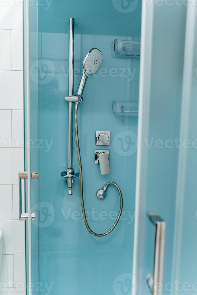 A shower with a shower head and a toilet photo
