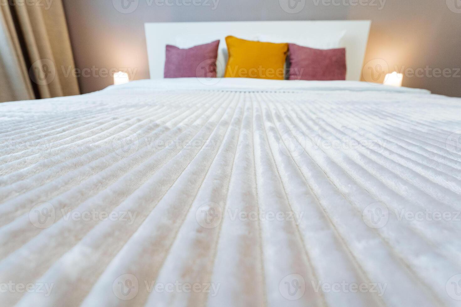 A bed with a white comforter and pillows photo