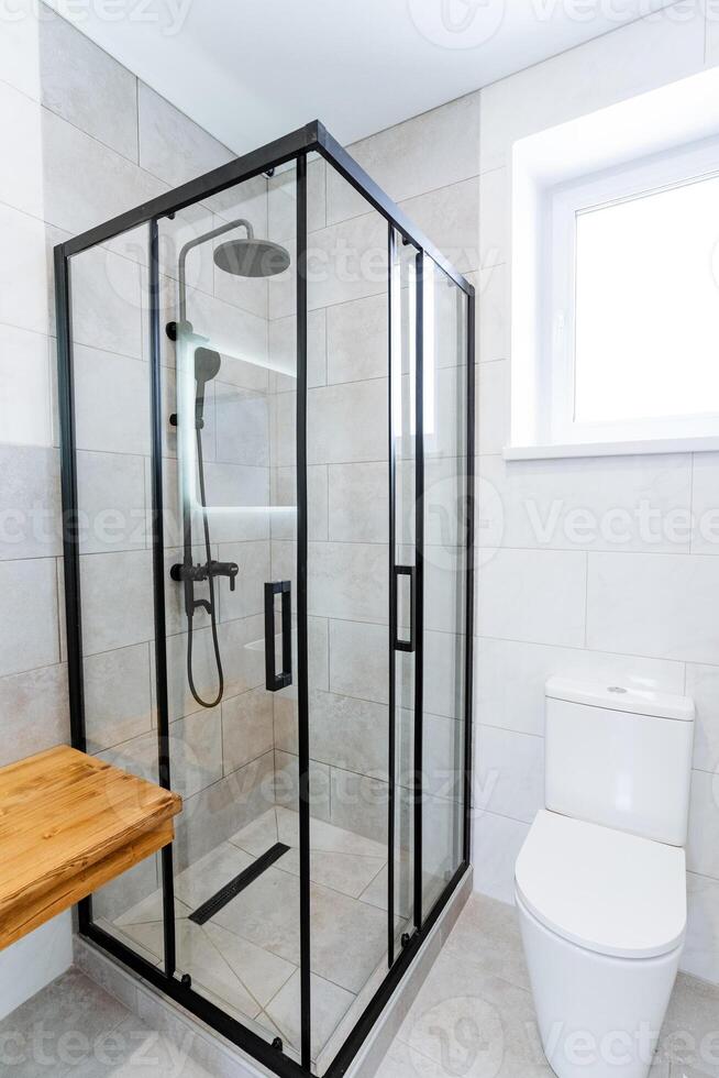 A bathroom with a glass shower stall and toilet photo