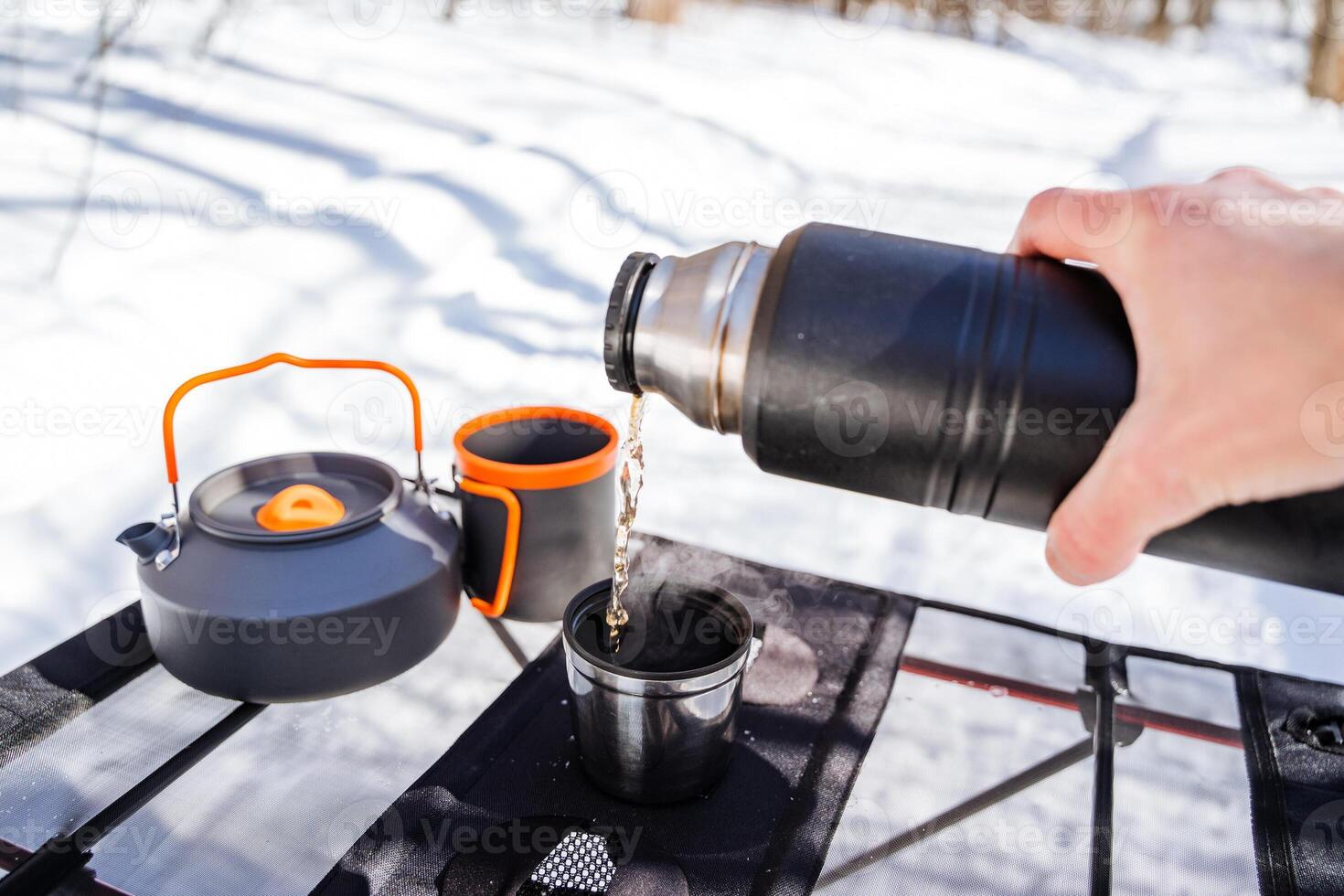 A person pours hot water into a coffee pot photo