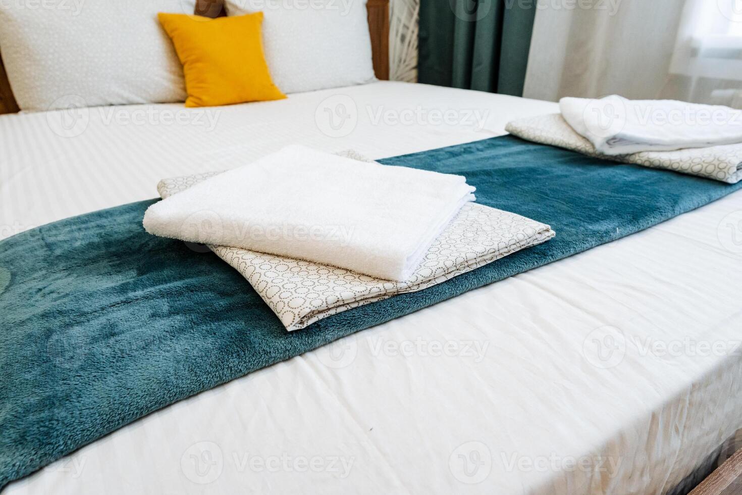 A bed with white sheets and towels on it photo