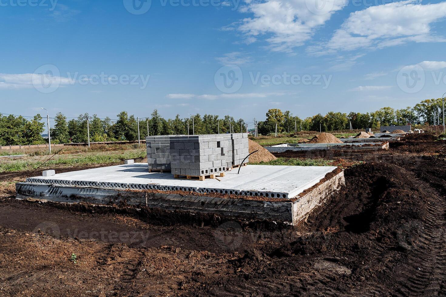 A concrete foundation is being built in a field photo