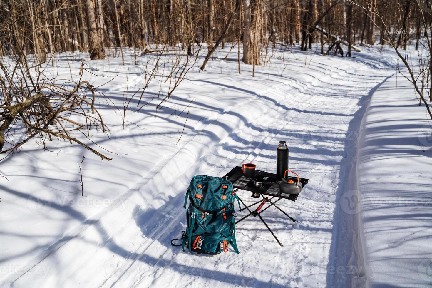A backpack and a chair on a snow covered trail photo