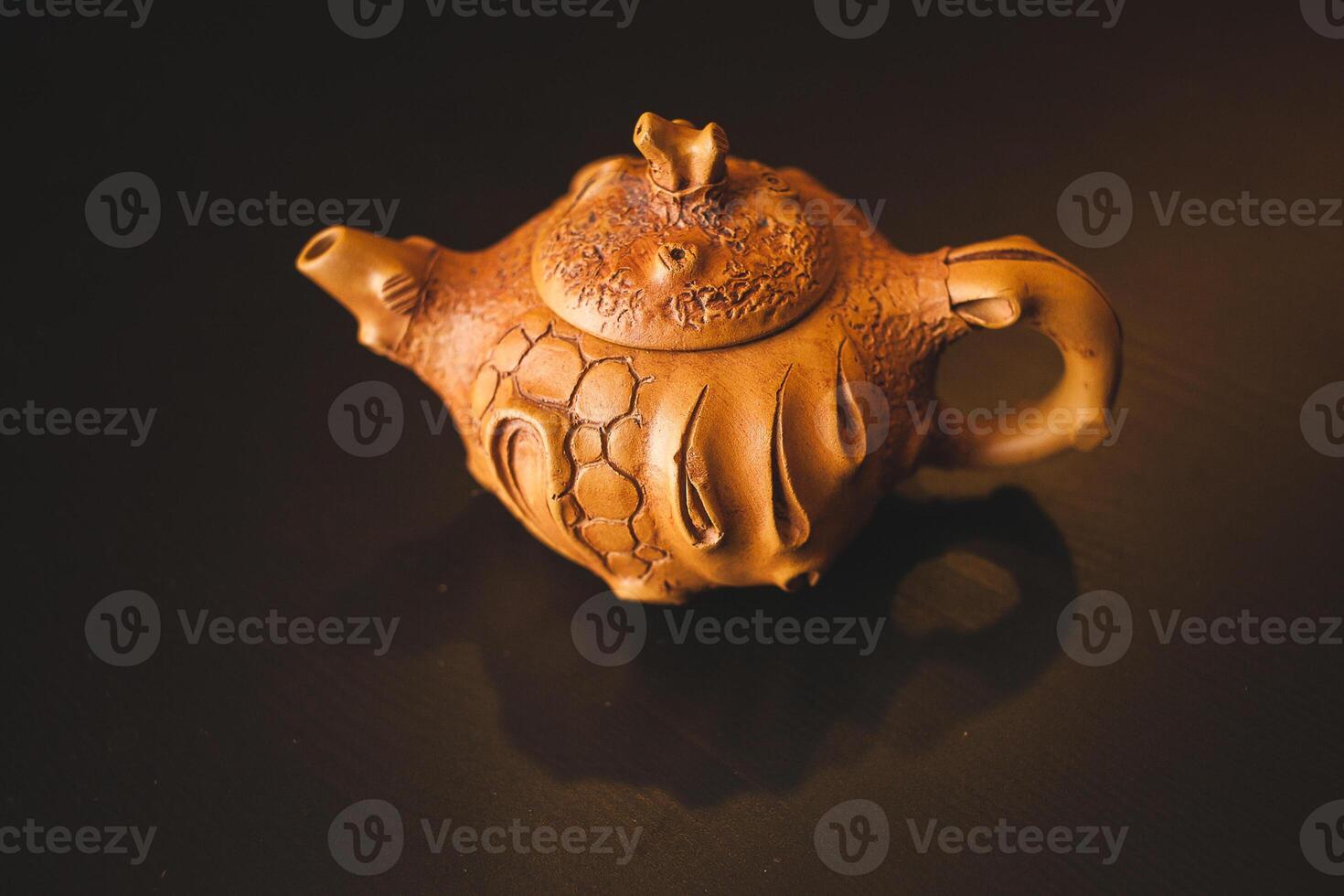A small clay teapot sitting on a table photo