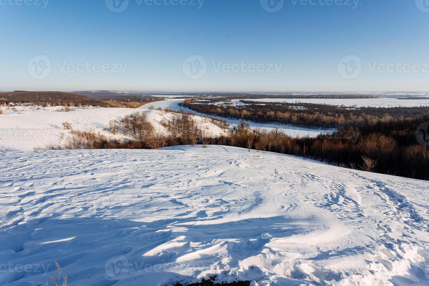 A view of a snowy landscape from a hilltop photo
