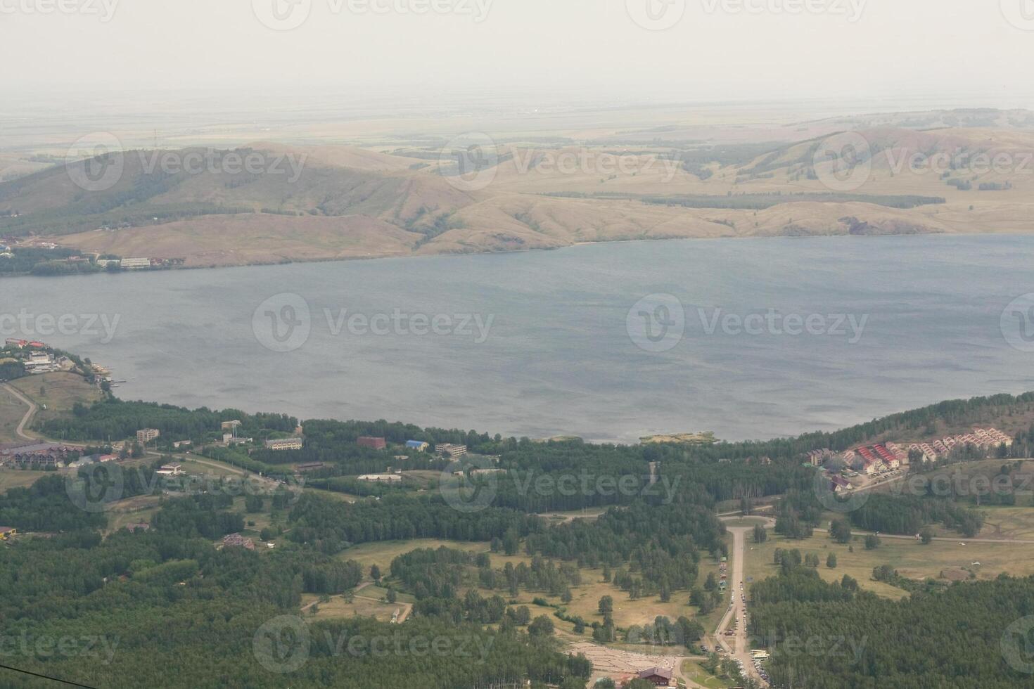 An aerial view of a lake and mountains photo