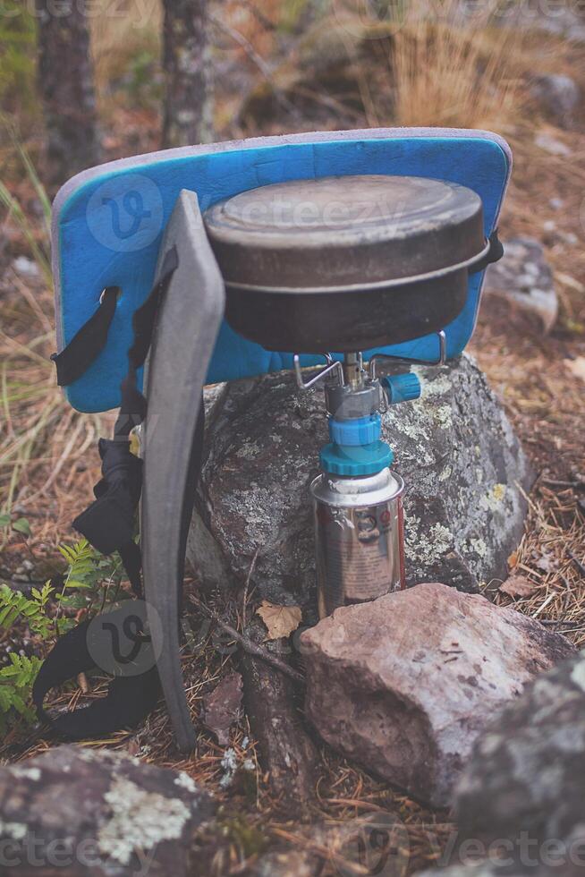 A blue and gray backpack sitting on a rock photo