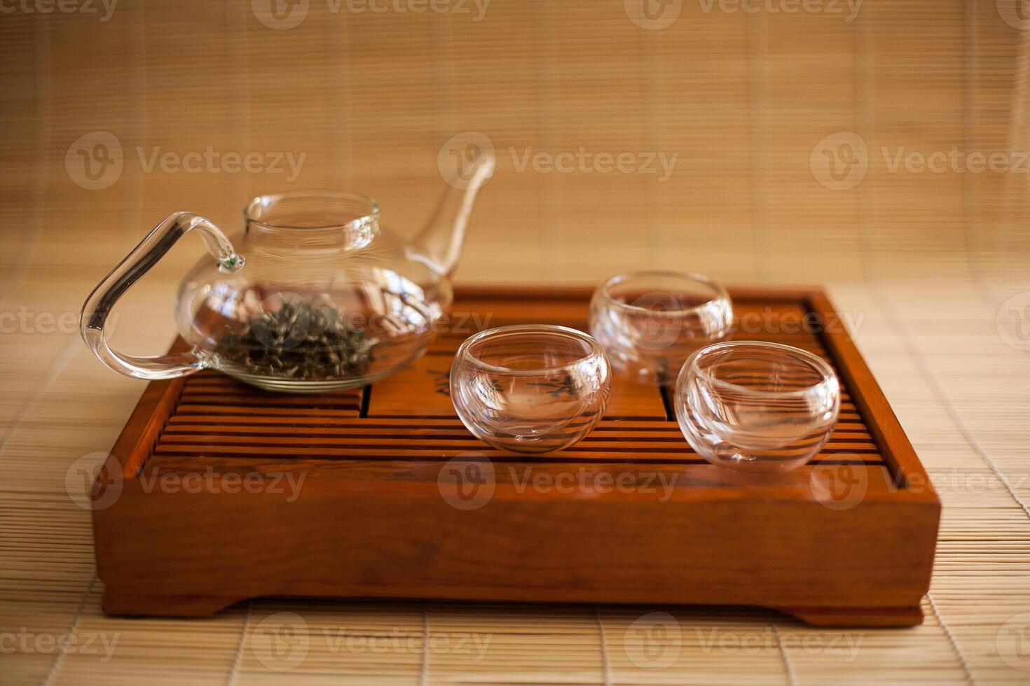 A wooden tray with tea cups and a teapot on it photo