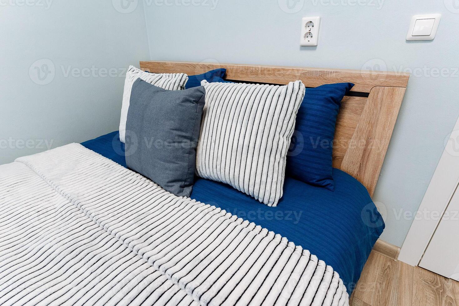 A bed with blue and white striped comforter photo