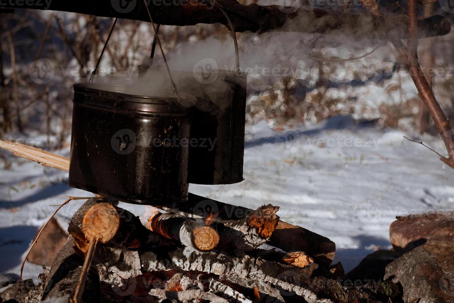 A pot of boiling water is sitting on top of a fire photo