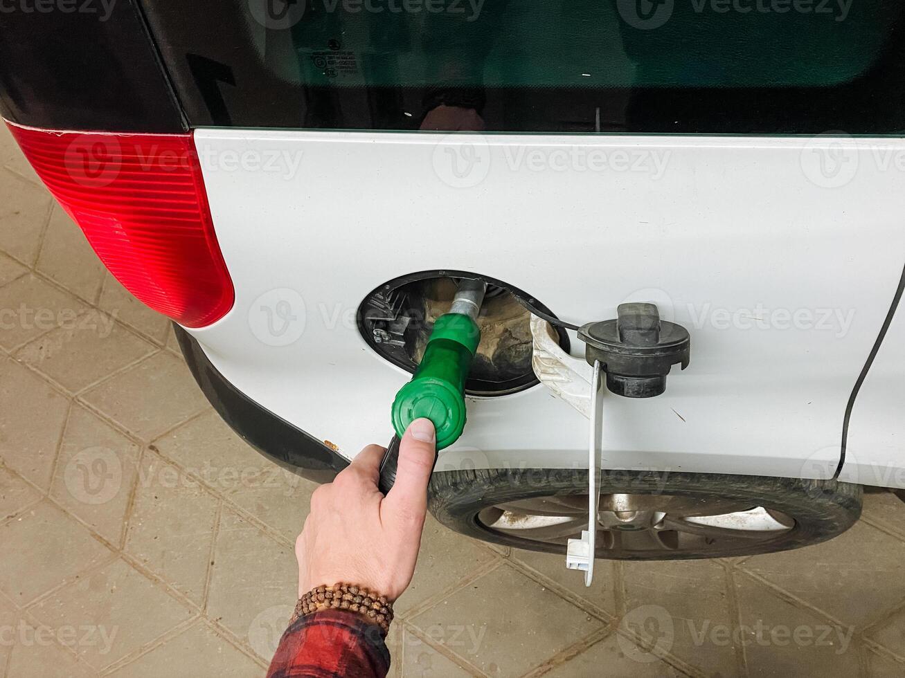 A person filling up a car with gas photo