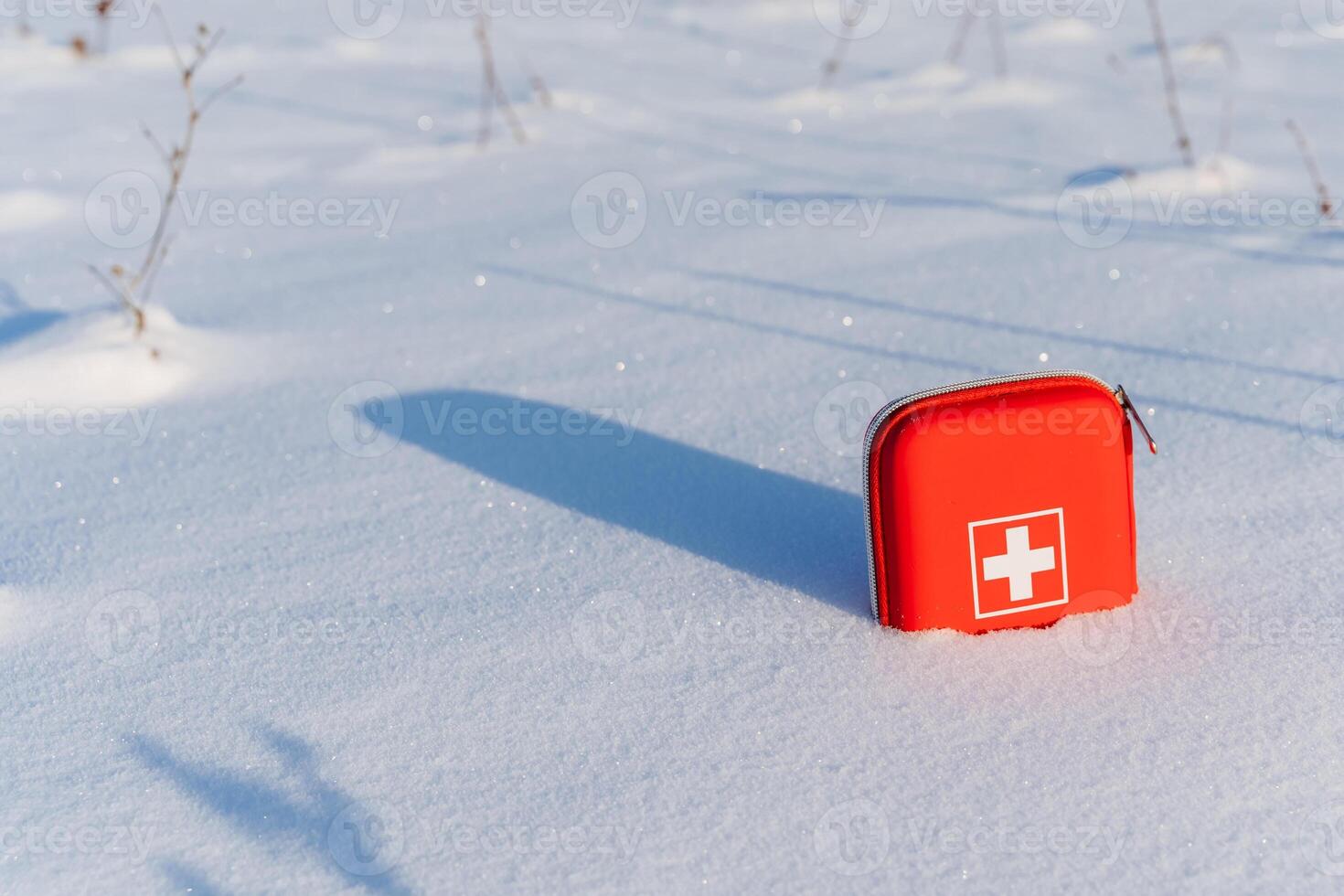 A red first aid kit sitting in the snow photo