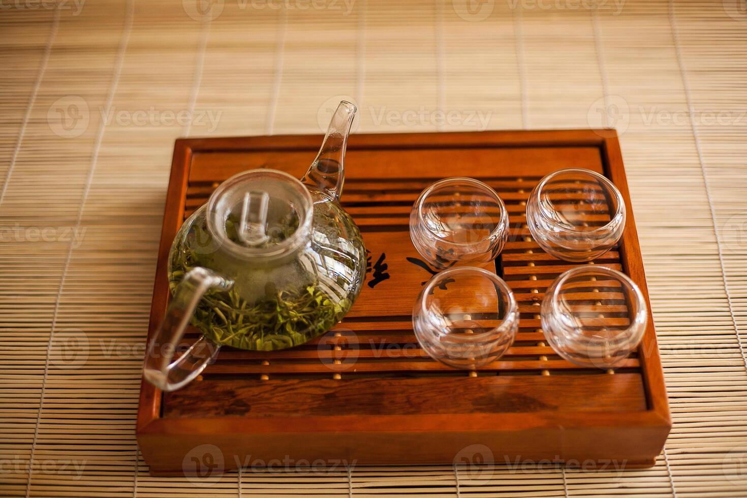 A wooden tray with a tea pot and glasses photo