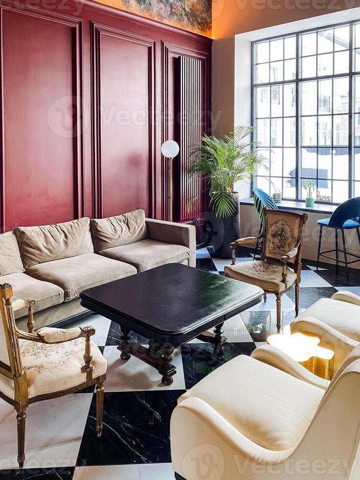 A living room with red walls and black and white checkered floor photo