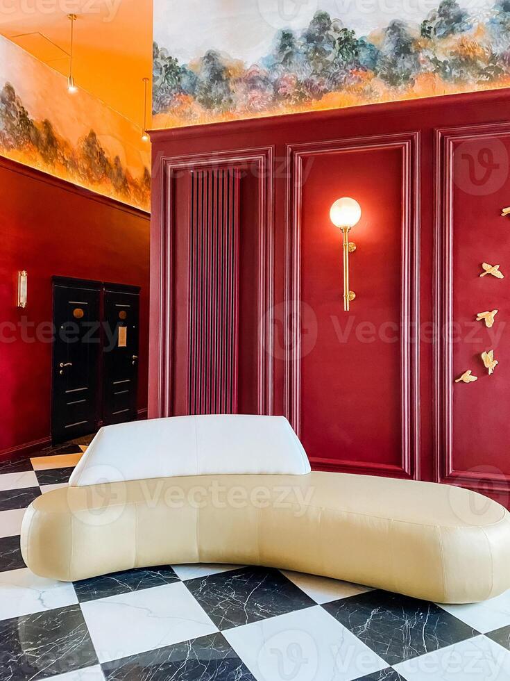 A red and black checkered floor with a white couch photo