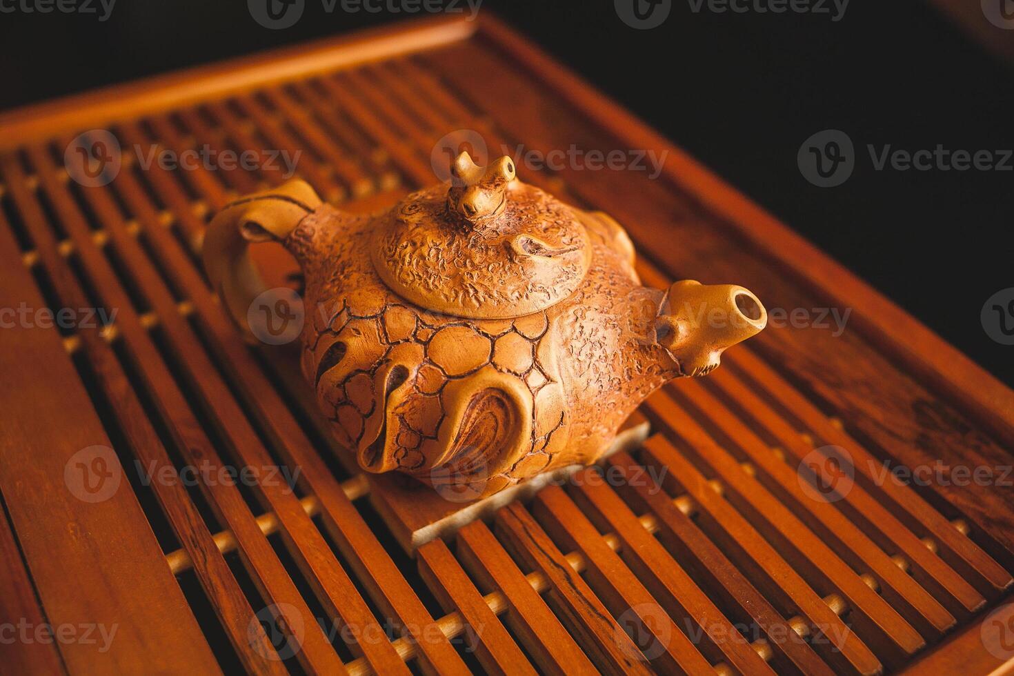 A wooden teapot sitting on a wooden tray photo