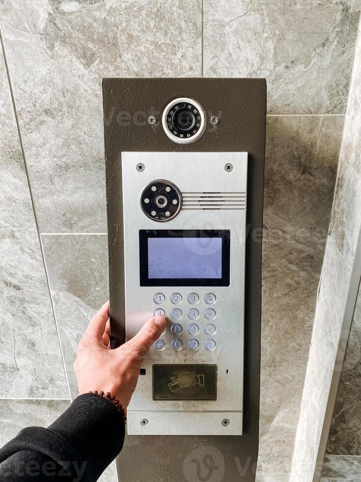 A person is pressing a button on a intercom photo