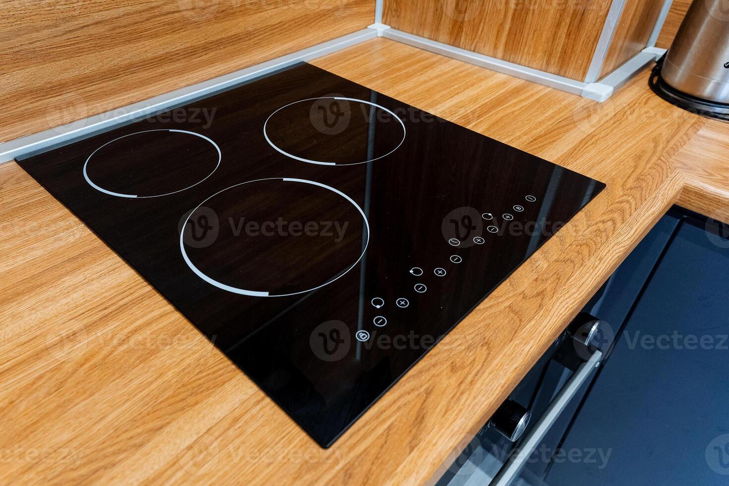 A black glass stove top on a wooden counter photo