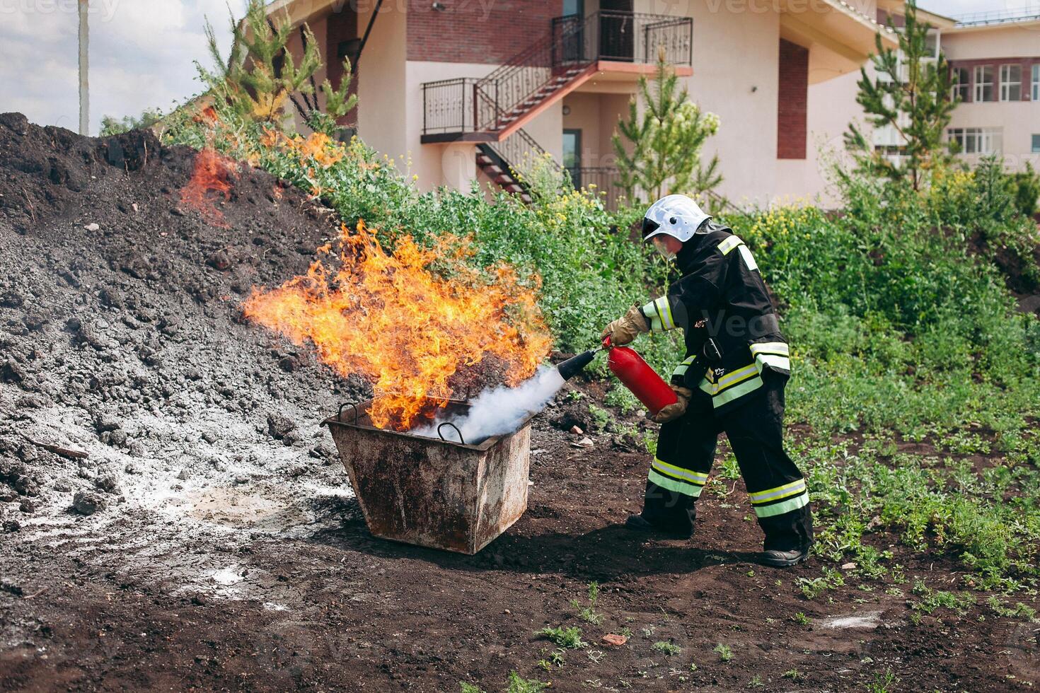 Firefighter extinguishing fire in a bucket photo